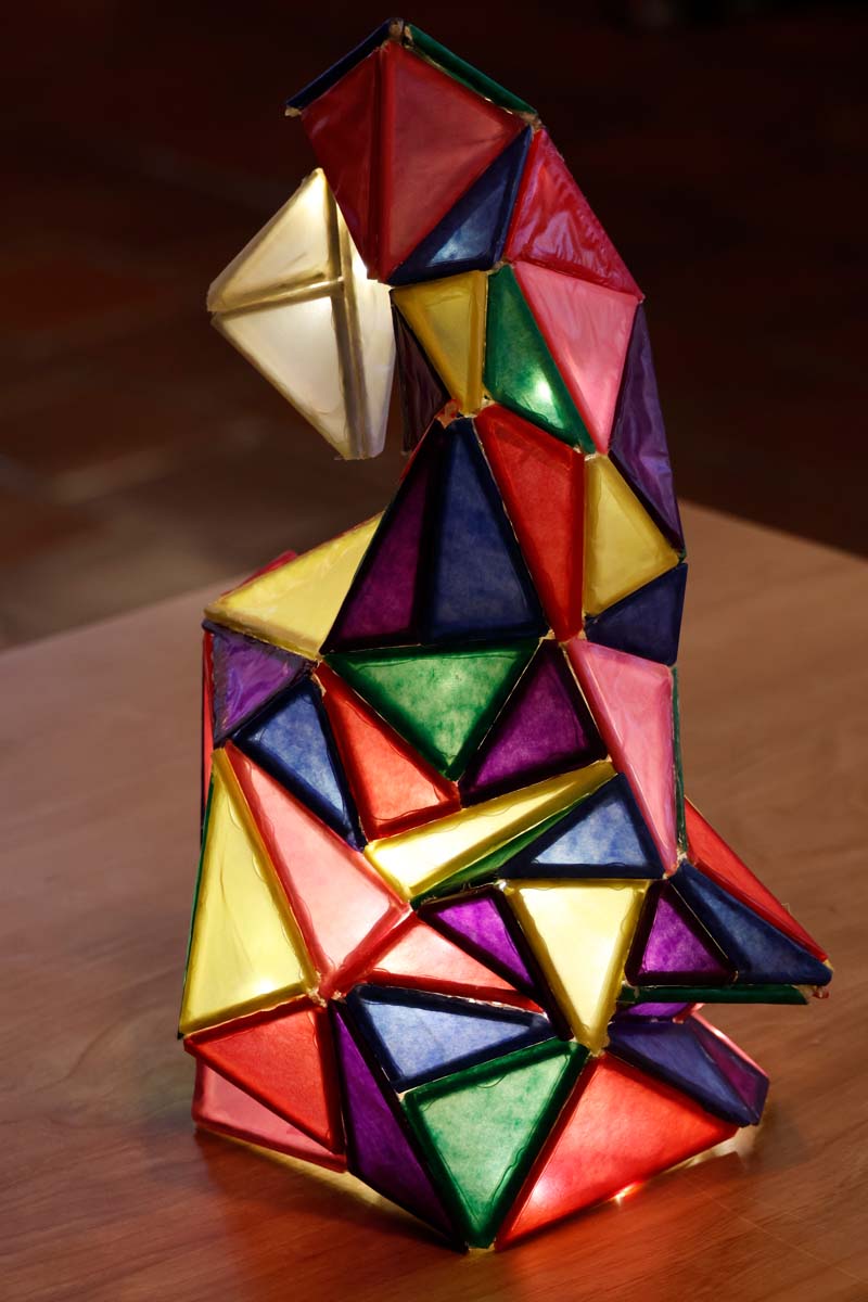 A lamp glows with different colored triangels form to make a geometric shape