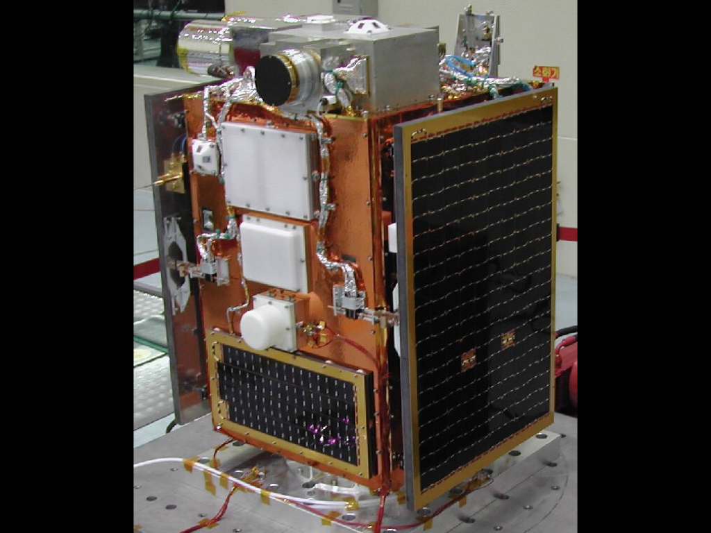 A small satellite, shorter than a human, with complex tubing and orange metal. Looks like B2EMO.